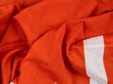 un t-shirt orange avec une bande blanche sur le devant et une bande blanche dans le dos
