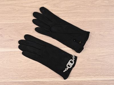 a pair of black gloves sitting on top of a wooden floor