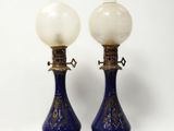 une paire de vases bleus et blancs rehaussés de touches dorées sur fond blanc