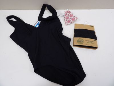 black one piece swimsuit next to a package of underwear on a white surface
