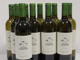 six bottles of wine are lined up in a row on a white surface