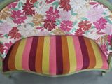 a pink and orange striped chair with flowers on it