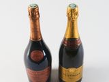 two bottles of champagne sitting next to each other on a white surface