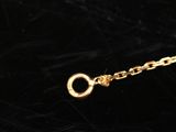 a close up of a gold chain with a clasp on a black surface