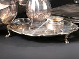un plateau en argent sur lequel sont posés une théière et une tasse en argent