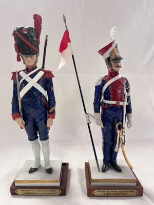 pair of figurines of two soldiers with flags on wooden bases