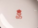 a white plate with a red crown on it