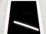 une tablette posée sur une table, sur fond noir