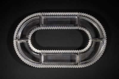 une image représentant un récipient en plastique transparent posé sur une surface noire