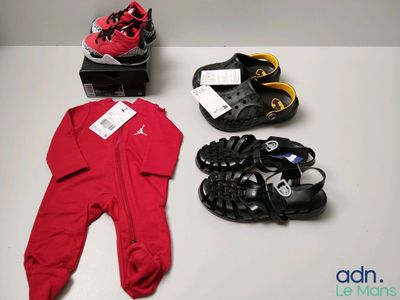 three pairs of shoes and a baby ' s footwear laid out on a table