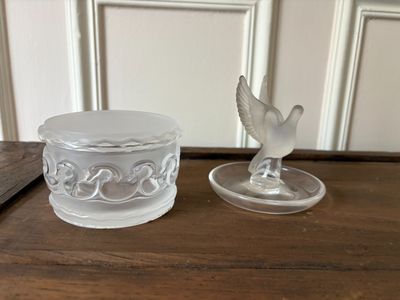 un bougeoir en verre surmonté d'un oiseau