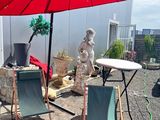 deux chaises de jardin et une table avec un parasol rouge