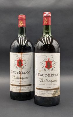 two bottles of red wine sitting next to each other on a table