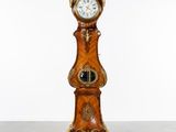 a clock that is sitting on a stand on the floor