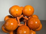 a wooden sculpture of a bunch of balls on a table