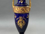 a blue vase with gold decoration on it sitting on a table