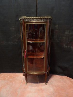 une petite armoire d'angle dotée d'une porte vitrée