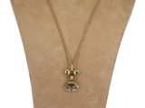 un gros plan sur un collier orné d'un ours en peluche, porté par un mannequin
