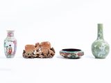 trois vases et un bol posés les uns à côté des autres sur une surface blanche