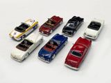 several toy cars are lined up in a row on a white surface