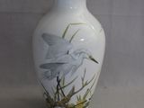 un vase blanc orné d'une peinture représentant un oiseau