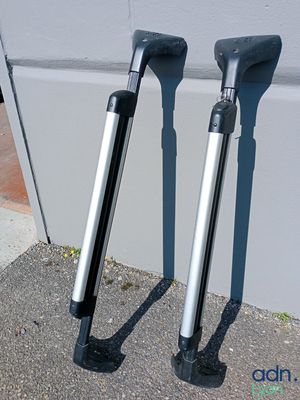 two black and silver crutches sitting on the sidewalk