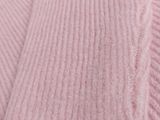 a close up of a pink blanket on a bed next to a pillow