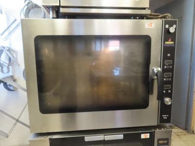 a silver microwave sitting on top of a metal oven