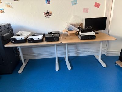 un bureau sur lequel se trouvent deux ordinateurs et une imprimante