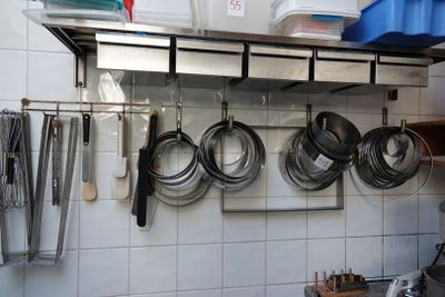 des casseroles et des poêles sont suspendues à un mur dans une cuisine