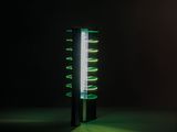 une lampe noire avec des lumières vertes qui brillent dans le noir