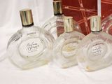 several bottles of perfume are lined up on a white cloth