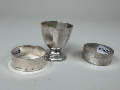 une coupe en argent et deux autres objets en argent posés sur une table