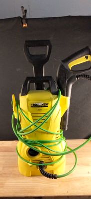 un manomètre jaune et noir posé sur une table, muni d'un tuyau vert