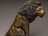 bronze statue of a lion sitting on its hind legs