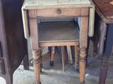 a small table with a drawer on it next to a chair