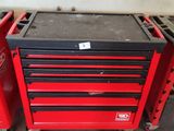 a red tool box and a black tool box on wheels in a garage