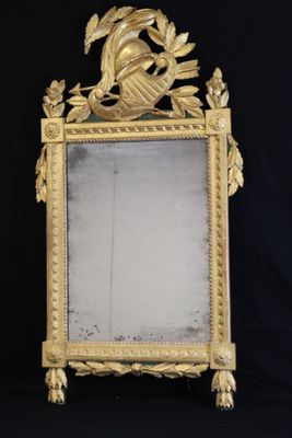 an image of a gold mirror with a bird on top of it