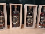 trois bouteilles d'alcool dans des caisses en bois posées sur une table