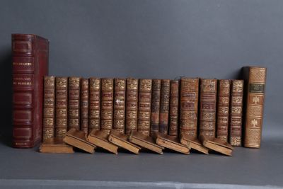 many old books lined up on a shelf next to each other