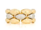 a close up of a gold and silver bracelet on a white surface