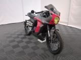 une photo d'une moto rouge et noire garée sur un sol à damier noir et blanc