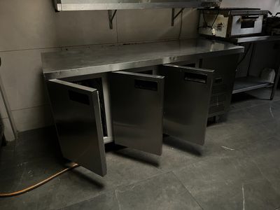 une cuisine avec des plans de travail en acier inoxydable et un micro-ondes
