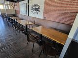 des tables et des chaises dans un restaurant aux murs en briques et au plafond apparu