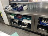 stainless steel counter top in a commercial kitchen with dishes and utensils on it