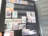 une personne tenant un livre sur lequel figurent des timbres