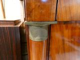 a close up of a door handle on a wooden cabinet