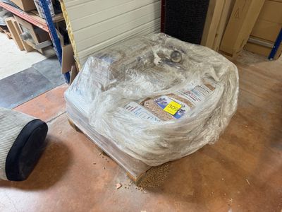 un matelas emballé dans du plastique, posé à même le sol