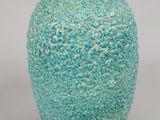 a blue vase with a black lid sitting on a table