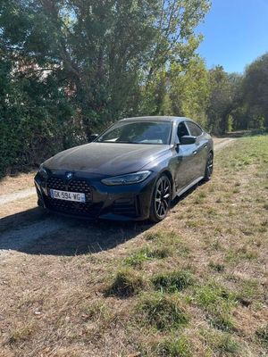 une voiture noire garée sur le bord d'un chemin de terre